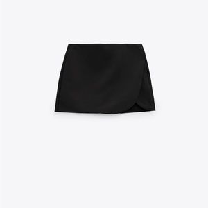 High waist skort. Pareo style self overlay. Side hidden in-seam zip closure.